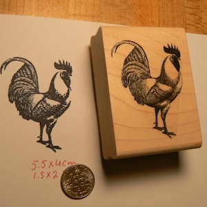 Peut inclure: Un tampon en caoutchouc en bois avec une illustration en noir et blanc d'un coq. Le tampon mesure 5,5 x 4 cm et 1,5 x 2 pouces.