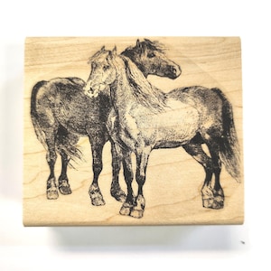 May include: A wood mounted rubber stamp featuring a black and white line drawing of two horses standing side by side.