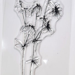 Puede incluir: Hoja de sello transparente con un diseño de un ramo de flores de línea negra.