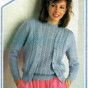 May include: A light blue knit cardigan and matching top set featuring a vertical lace stitch pattern on the front panels. The cardigan has a round neckline, long sleeves with ribbed cuffs, and a button-down front with small matching blue buttons.