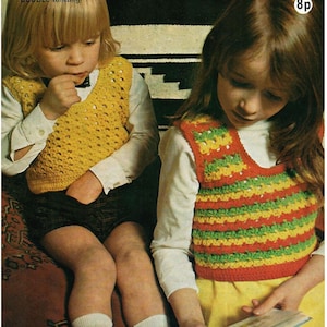 May include: Two children wearing handmade crochet vests. One vest is yellow, the other is red, green, and yellow striped. The vests are worn over white long-sleeved shirts. The image has a vintage, retro aesthetic.