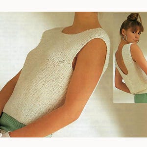 May include: A cream-colored, sleeveless knitted top with a scoop neck. The top has a textured appearance and a slightly open back. The model is wearing the top with a pair of green shorts. The top is a vintage style.