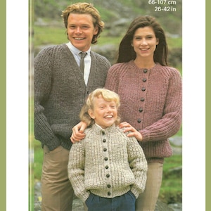 May include: A family in knitted cardigans. The man wears a grey cardigan over a white shirt and tie. The woman wears a mauve cardigan. The child wears a beige cardigan. The image text reads: 66-107 cm, 26-42 in.