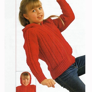 May include: A red knitted hooded jacket with a zipper closure. The jacket has a textured pattern and is worn with blue jeans. A smaller inset image shows the jacket's hood.