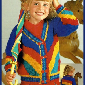 Könnte beinhalten: Ein farbenfroher Strickcardigan mit einem Regenbogenmuster und Knopfleiste. Der Cardigan ist blau, rot, gelb und grün. Das Kind hält einen gestreiften Regenschirm.