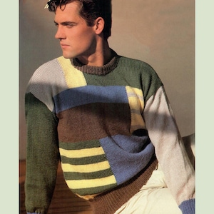Peut inclure: Un pull en tricot multicolore avec un motif patchwork. Le pull présente un mélange de couleurs vertes, brunes, bleues, jaunes et blanches.