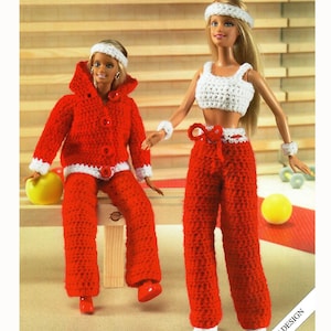 May include: Two dolls dressed in handmade crochet outfits. One doll wears a red hooded jacket and trousers with white trim. The other doll is in a white crop top and red trousers. Both dolls have white headbands and wristbands. The outfits are handmade.