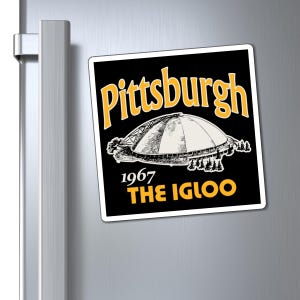May include: A square magnet with the words "Pittsburgh" in gold arched text above a black and white illustration of a domed building. Below the building are the words "1967 THE IGLOO" in gold.