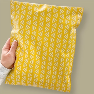 May include: A yellow poly mailer with a white chevron pattern. The mailer is made of a durable, waterproof material and is ideal for shipping small items.