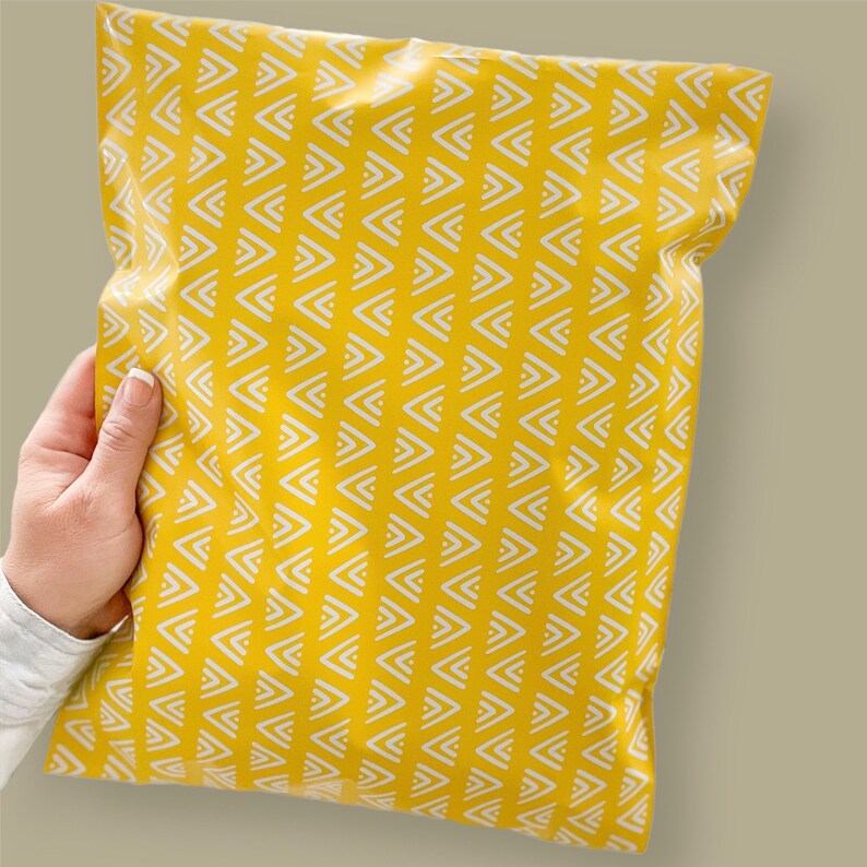 May include: A yellow poly mailer with a white chevron pattern. The mailer is made of a durable, waterproof material and is ideal for shipping small items.