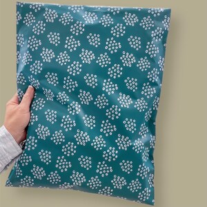 May include: Teal blue poly mailer with a white polka dot pattern. The mailer is made of a durable, water-resistant material.