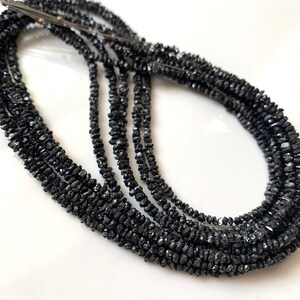 May include: A strand of black diamond beads, with a rough, faceted texture. The beads are strung on a thin wire and are approximately 3mm in diameter.