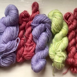 Può includere: Sei gomitoli di filato in vari colori pastello, tra cui azzurro, lavanda, rosa, verde chiaro e verde menta.