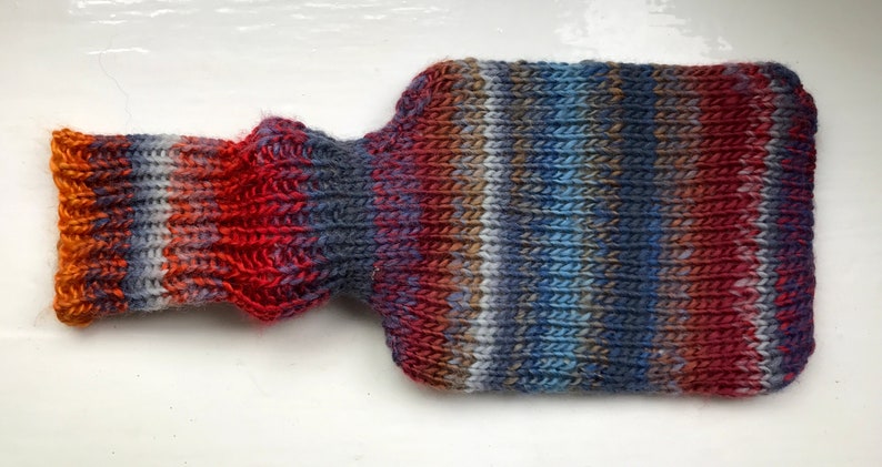 Mini hot water bottle and hand knitted lightly felted cozy, wool rich cover, mini 500ml, blended colours, reds, blues, glowing orange image 3