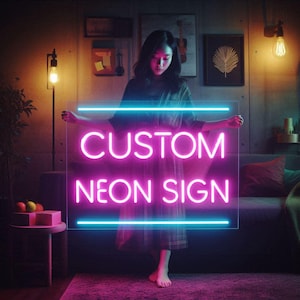 May include: A person holding a clear rectangular neon sign with the words "CUSTOM NEON SIGN" in bright pink neon. The sign has blue neon lines above and below the text. The background is a dimly lit room with a couch and decorative items.