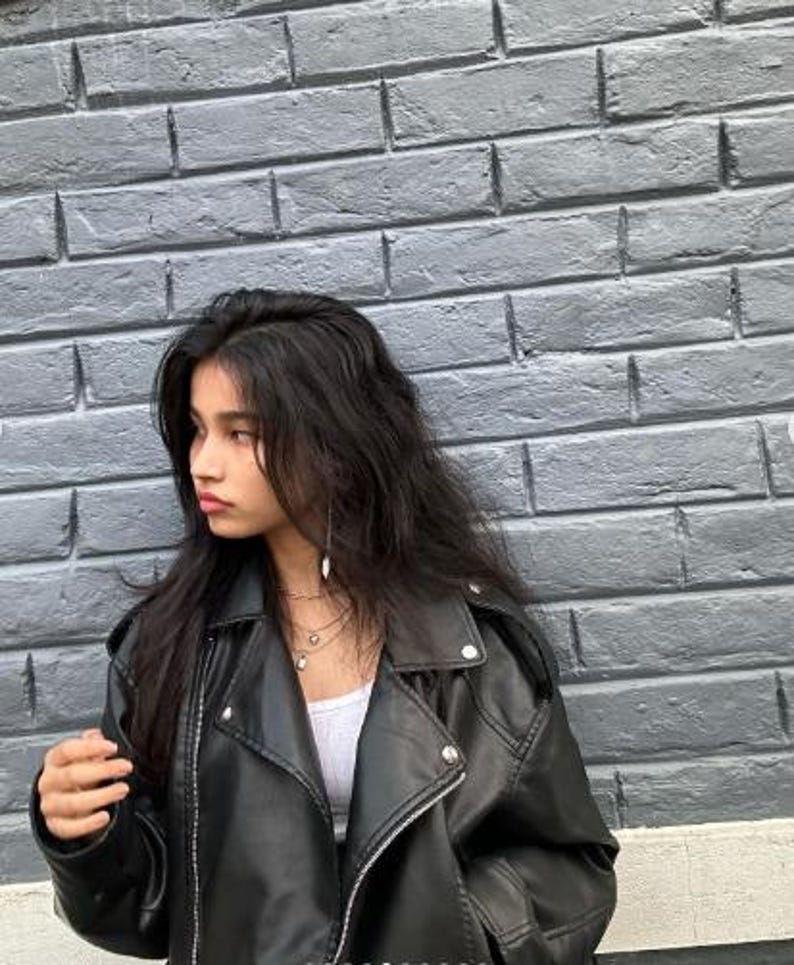 Oversized black faux leather biker jacket with asymmetric zip closure and bold lapel neckline, styled in modern Y2K streetwear fashion. This edgy moto jacket features a relaxed silhouette inspired by vintage bikerjacket trends and casual urban style. Perfect for fall winter outfits, minimalist fashion, and everyday casual wear, this trendy women leather jacket pairs effortlessly with denim, boots, and layered street style looks. A timeless faux leather outerwear piece for Etsy fashion lovers.