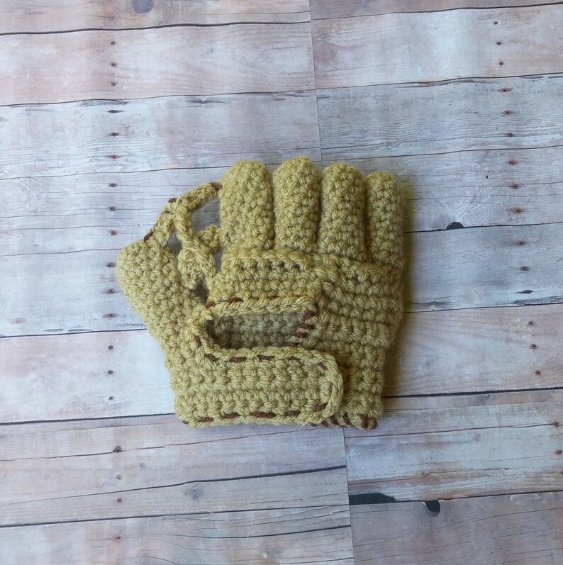 May include: A crocheted yellow baseball mitt with brown stitching.
