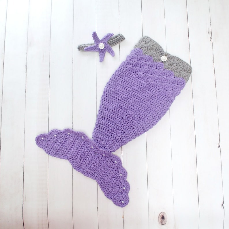 May include: Purple and gray crocheted mermaid tail costume with a starfish headband. The tail has a scalloped edge and is decorated with white beads.