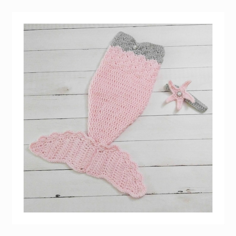 May include: A pink and gray crocheted mermaid tail costume with a matching starfish headband. The tail is made of soft yarn and has a scalloped edge. The headband is decorated with a pearl.