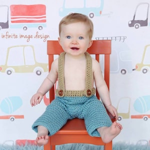 Puede incluir: Un bebé varón lleva un pantalón de crochet azul con tirantes y botones de crochet marrón, sentado en una silla de madera roja frente a una pared blanca con un patrón de coches. El texto "infinite image design" es visible en la esquina inferior izquierda de la imagen.
