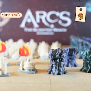 May include: A selection of miniature game pieces, including stylized trees, buildings, and flame-shaped tokens. The pieces are in various colours, including white, grey, blue, and green. The background features the text "ARCS" and "Cubic Robin" branding.