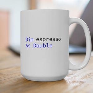 May include: White ceramic mug with the text "Dim espresso As Double" in blue and black font.