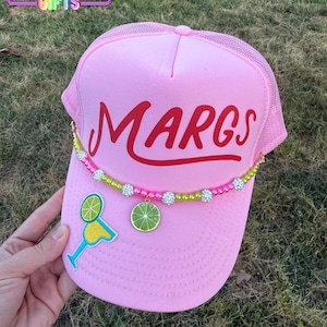 May include: Pink trucker hat with a red "MARGS" logo and a lime green and white beaded chain with lime slices and a margarita glass charm.