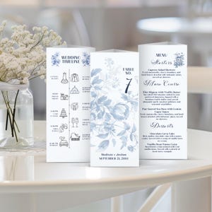 May include: Wedding stationery set featuring a timeline, table number, and menu. The designs include blue floral patterns and text. The menu lists starters, main courses, and desserts. The wedding date is September 21, 2034.