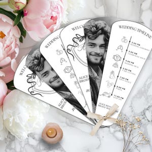 Può includere: Un ventaglio da matrimonio bianco con un designo in bianco e nero. Il ventaglio presenta una sequenza temporale del matrimonio con orari ed eventi, tra cui la cerimonia, l'ora del brindisi con lo champagne, il pranzo di nozze, il taglio della torta, il primo ballo, la festa e il congedo. Il ventaglio include anche un messaggio di benvenuto e i nomi Alice e Brody.