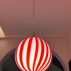 Hand blown glass globe pendant lights with red vertical strips for dinning room, kitchen island and living room lighting. Handmade glass globe ceiling lights in candy shape for modern lighting and home interior decoration. Glass globe chandelier.