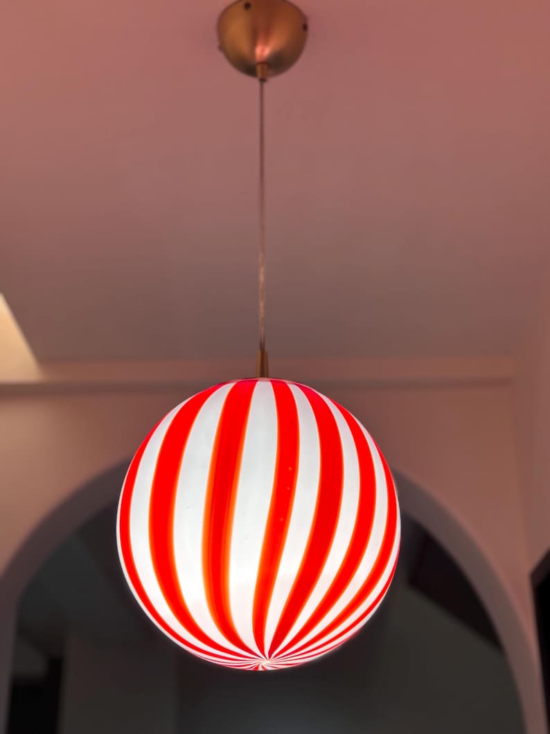 Hand blown glass globe pendant lights with red vertical strips for dinning room, kitchen island and living room lighting. Handmade glass globe ceiling lights in candy shape for modern lighting and home interior decoration. Glass globe chandelier.