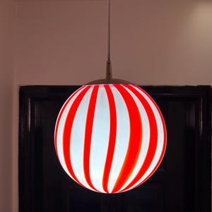 Hand blown glass globe pendant lights with red vertical strips for dinning room, kitchen island and living room lighting. Handmade glass globe ceiling lights in candy shape for modern lighting and home interior decoration. Glass globe chandelier.