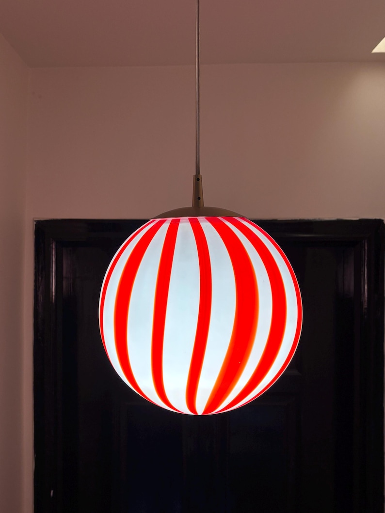 Hand blown glass globe pendant lights with red vertical strips for dinning room, kitchen island and living room lighting. Handmade glass globe ceiling lights in candy shape for modern lighting and home interior decoration. Glass globe chandelier.