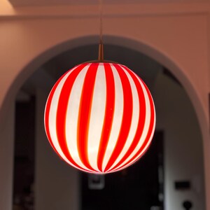 Hand blown glass globe pendant lights with red vertical strips for dinning room, kitchen island and living room lighting. Handmade glass globe ceiling lights in candy shape for modern lighting and home interior decoration. Glass globe chandelier.