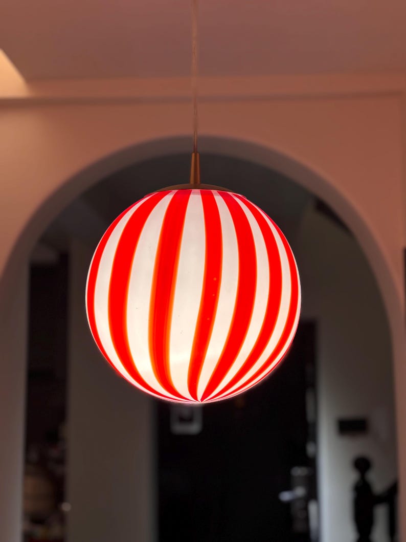 Hand blown glass globe pendant lights with red vertical strips for dinning room, kitchen island and living room lighting. Handmade glass globe ceiling lights in candy shape for modern lighting and home interior decoration. Glass globe chandelier.