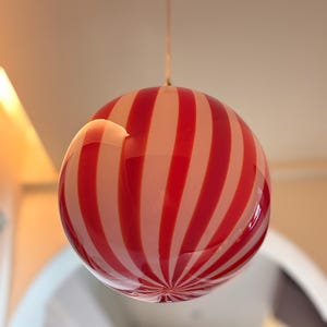 Hand blown glass globe pendant lights with red vertical strips for dinning room, kitchen island and living room lighting. Handmade glass globe ceiling lights in candy shape for modern lighting and home interior decoration. Glass globe chandelier.