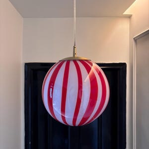 Hand blown glass globe pendant lights with red vertical strips for dinning room, kitchen island and living room lighting. Handmade glass globe ceiling lights in candy shape for modern lighting and home interior decoration. Glass globe chandelier.