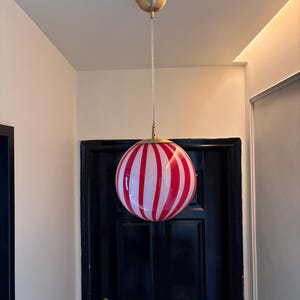 Hand blown glass globe pendant lights with red vertical strips for dinning room, kitchen island and living room lighting. Handmade glass globe ceiling lights in candy shape for modern lighting and home interior decoration. Glass globe chandelier.