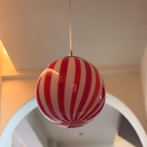 Hand blown glass globe pendant lights with red vertical strips for dinning room, kitchen island and living room lighting. Handmade glass globe ceiling lights in candy shape for modern lighting and home interior decoration. Glass globe chandelier.