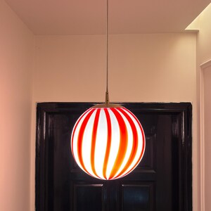 Hand blown glass globe pendant lights with red vertical strips for dinning room, kitchen island and living room lighting. Handmade glass globe ceiling lights in candy shape for modern lighting and home interior decoration. Glass globe chandelier.