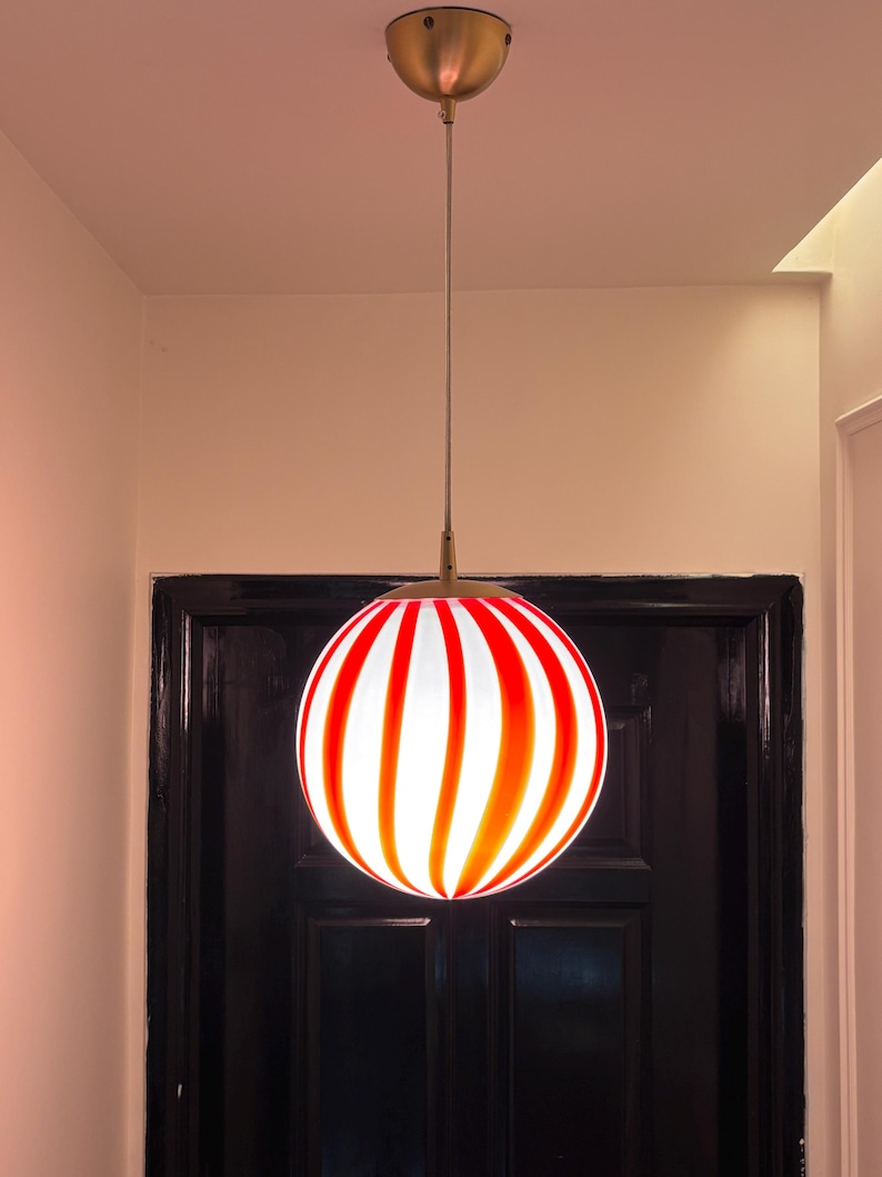 Hand blown glass globe pendant lights with red vertical strips for dinning room, kitchen island and living room lighting. Handmade glass globe ceiling lights in candy shape for modern lighting and home interior decoration. Glass globe chandelier.