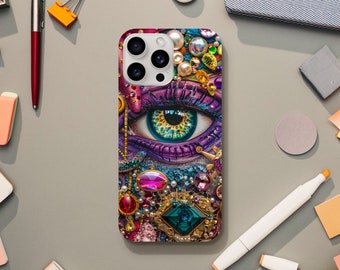 May include: A colorful phone case with a large eye design surrounded by jewels and pearls. The eye is purple, blue, and green with a yellow iris. The case has a camera lens cutout and a white background.