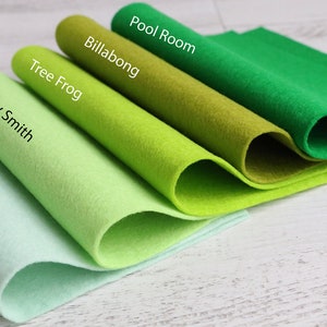 Puede incluir: Cinco muestras de tela de fieltro de diferentes tonos de verde, enrolladas y etiquetadas con nombres como "Pool Room", "Billabong", "Tree Frog", "Granny Smith" y "River Gum".