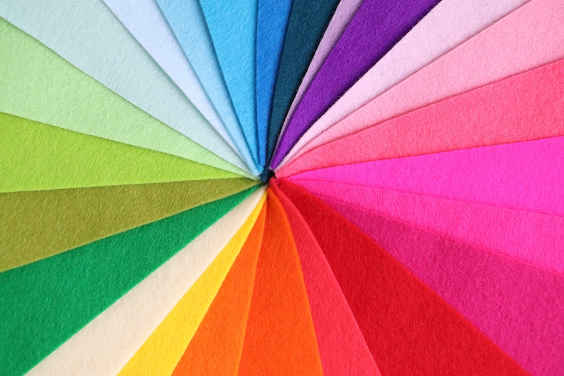 Puede incluir: Un arco&iacute;ris de muestras de tela de fieltro dispuestas en un patr&oacute;n circular. Los colores van del azul claro al morado oscuro.