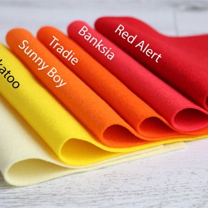 Puede incluir: Cinco muestras de tela de fieltro de diferentes colores, dispuestas en degradado de amarillo claro a rojo. Las muestras est&aacute;n etiquetadas con los nombres "Custard Tart", "Cockatoo", "Sunny Boy", "Tradie", "Banksia" y "Red Alert".