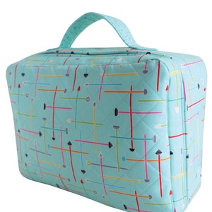 Puede incluir: Una bolsa de mano acolchada de color azul turquesa con cremallera y asa negra. La bolsa tiene un patr&oacute;n geom&eacute;trico de l&iacute;neas y formas de colores.