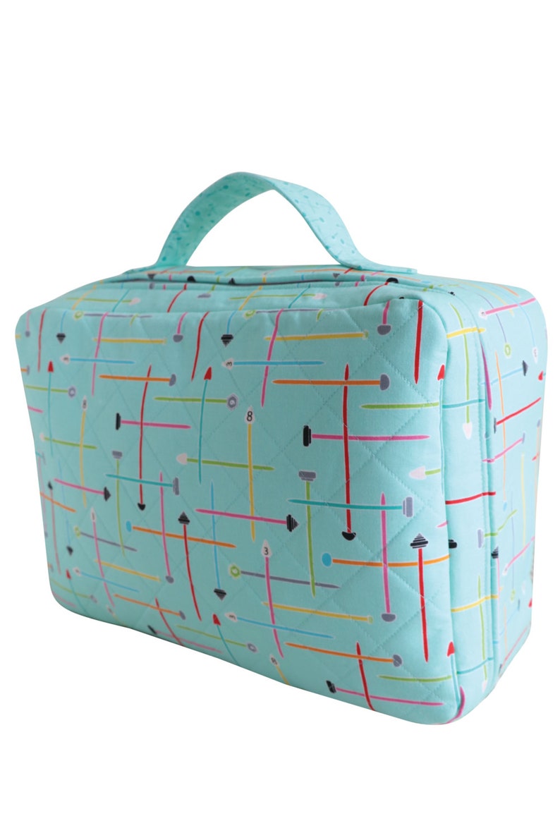 Puede incluir: Una bolsa de mano acolchada de color azul turquesa con cremallera y asa negra. La bolsa tiene un patr&oacute;n geom&eacute;trico de l&iacute;neas y formas de colores.
