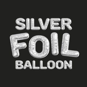 May include: Silver foil balloon spelling out "SILVER FOIL BALLOON" in capital letters. The letters are silver and have a metallic sheen, with a reflective quality. The background is a solid black.