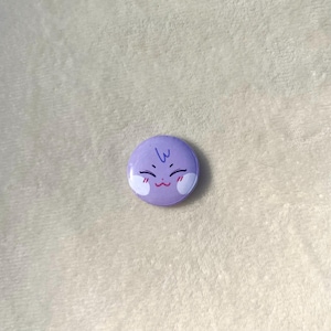 Puede incluir: Bot&oacute;n morado con una cara de dibujos animados con una peque&ntilde;a sonrisa y rubor. La cara tiene dos peque&ntilde;os c&iacute;rculos blancos para los ojos y una peque&ntilde;a l&iacute;nea azul para el cabello.