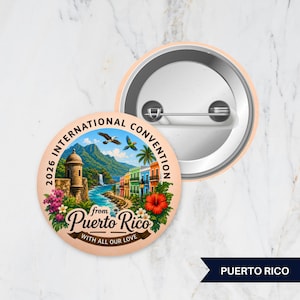 May include: A round pinback button featuring a colorful illustration of a coastal Puerto Rican landscape with a historic stone fort, vibrant buildings, tropical flowers, and birds. The text reads 2026 INTERNATIONAL CONVENTION from Puerto Rico WITH ALL OUR LOVE.